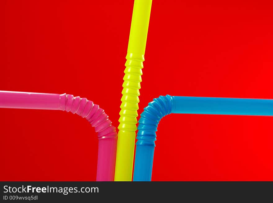 Red Background with close-up of multi colored drinking straw