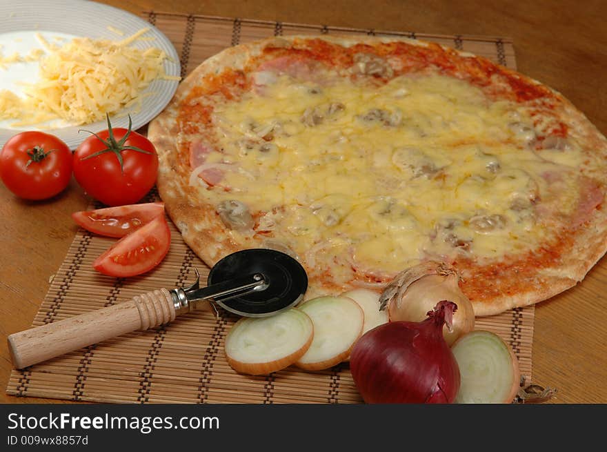 Pizza lying on the table ready for cutting