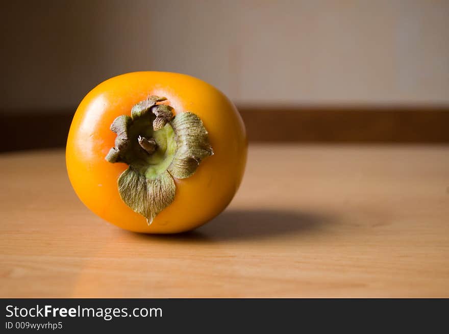 Picture of a sweet persimmon on a wooden table