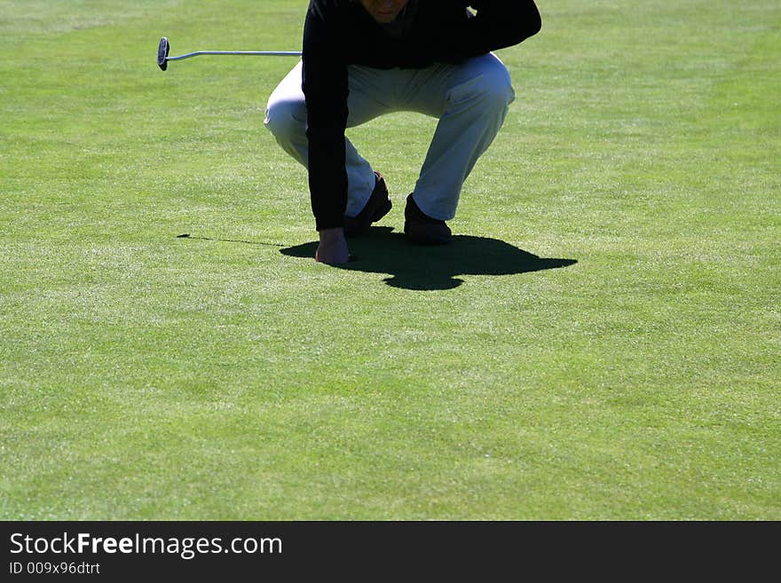 Man picking the ball in the hole. Man picking the ball in the hole