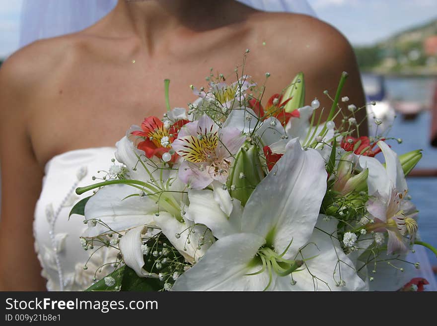 Young pretty bride with bouquet of lilies. Soft-focused, focus on the flowers. Young pretty bride with bouquet of lilies. Soft-focused, focus on the flowers