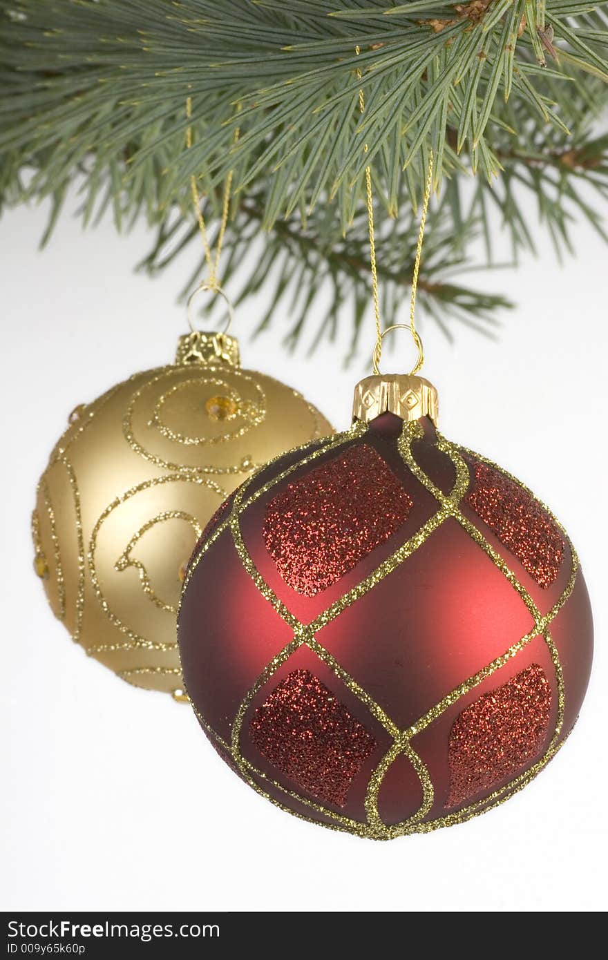 Red and Gold Christmas decorations hanging from a xmas tree branch. Red and Gold Christmas decorations hanging from a xmas tree branch