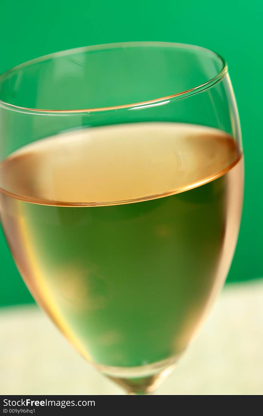 Glass of wine on green background