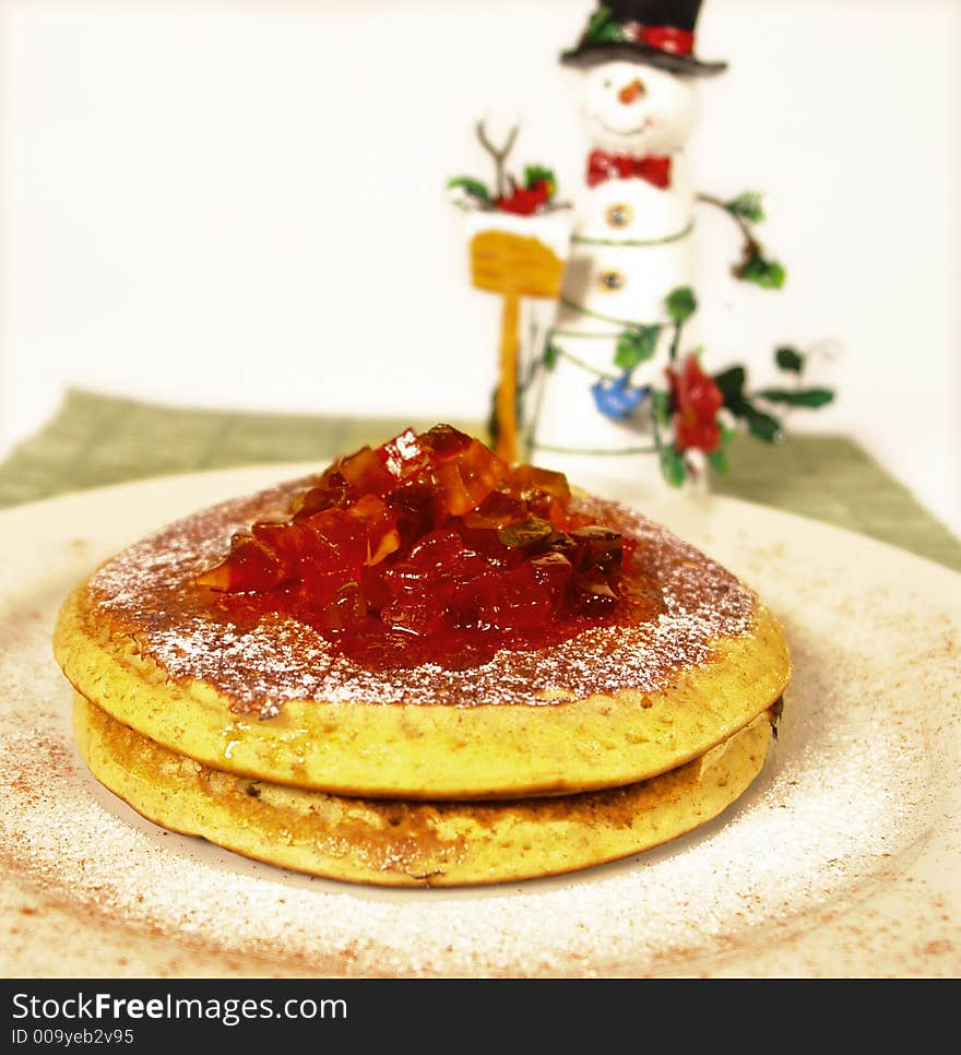 Homemade pancakes with candied fruit and powdered sugar and snowman decoration