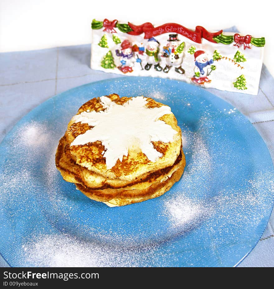 Homemade pancakes with powdered sugar and snowman decoration