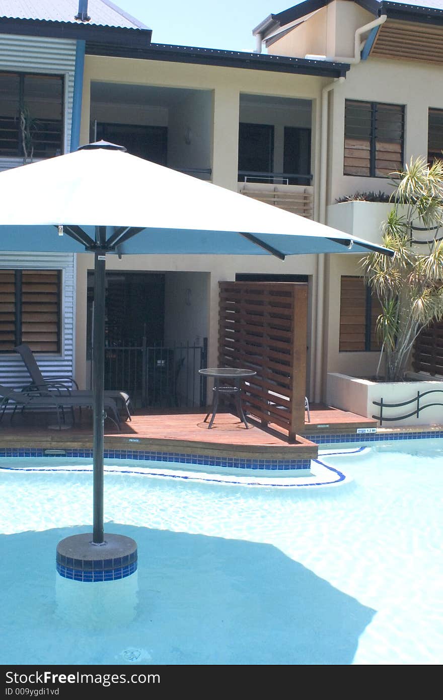 Balcony and umbrella next to outdoor hotel pool. Balcony and umbrella next to outdoor hotel pool