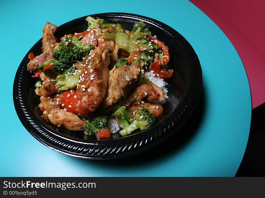 A chicken broccoli rice bowl sits at the end of a table