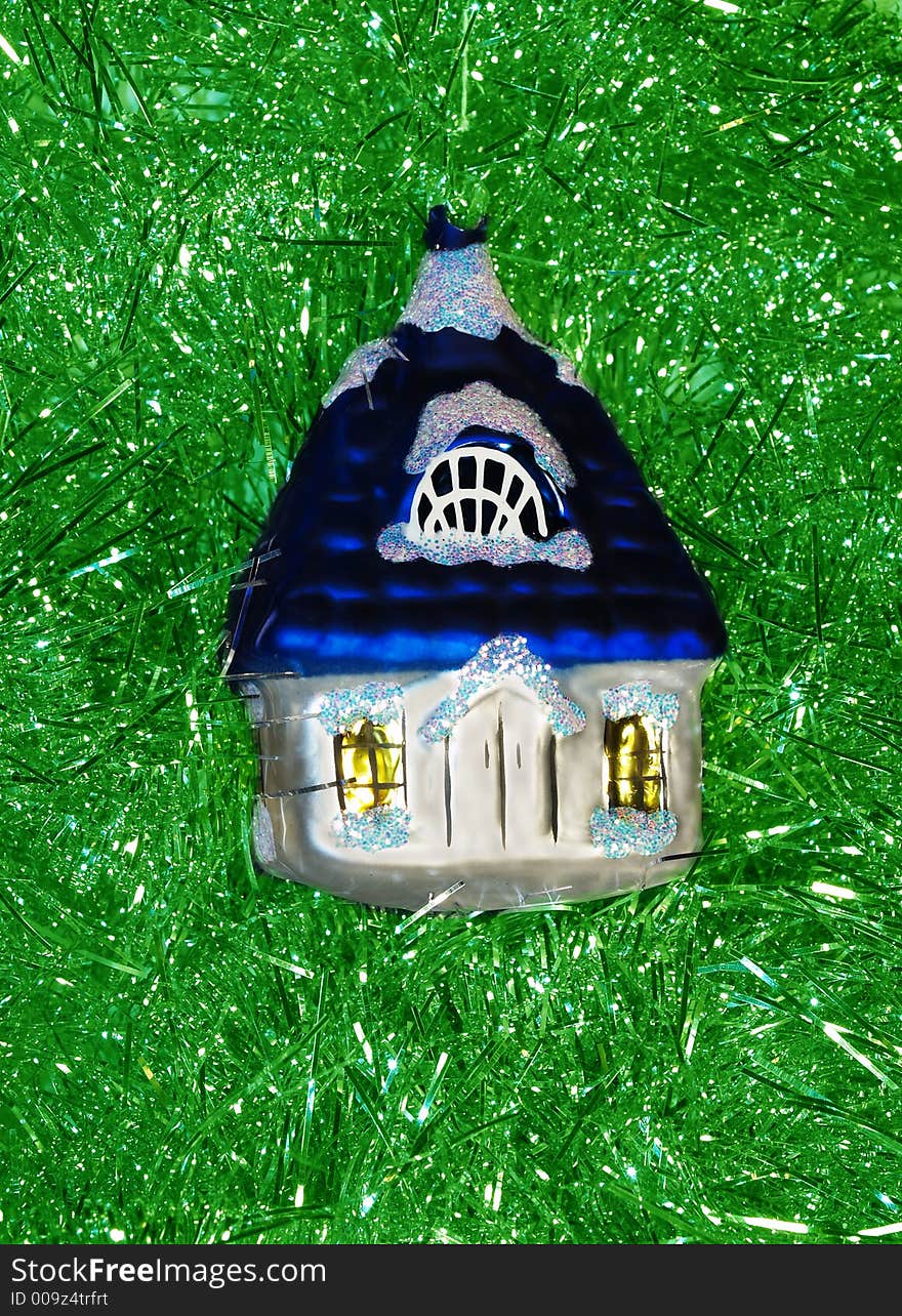 Christmas glass decoration coloured little house on green background