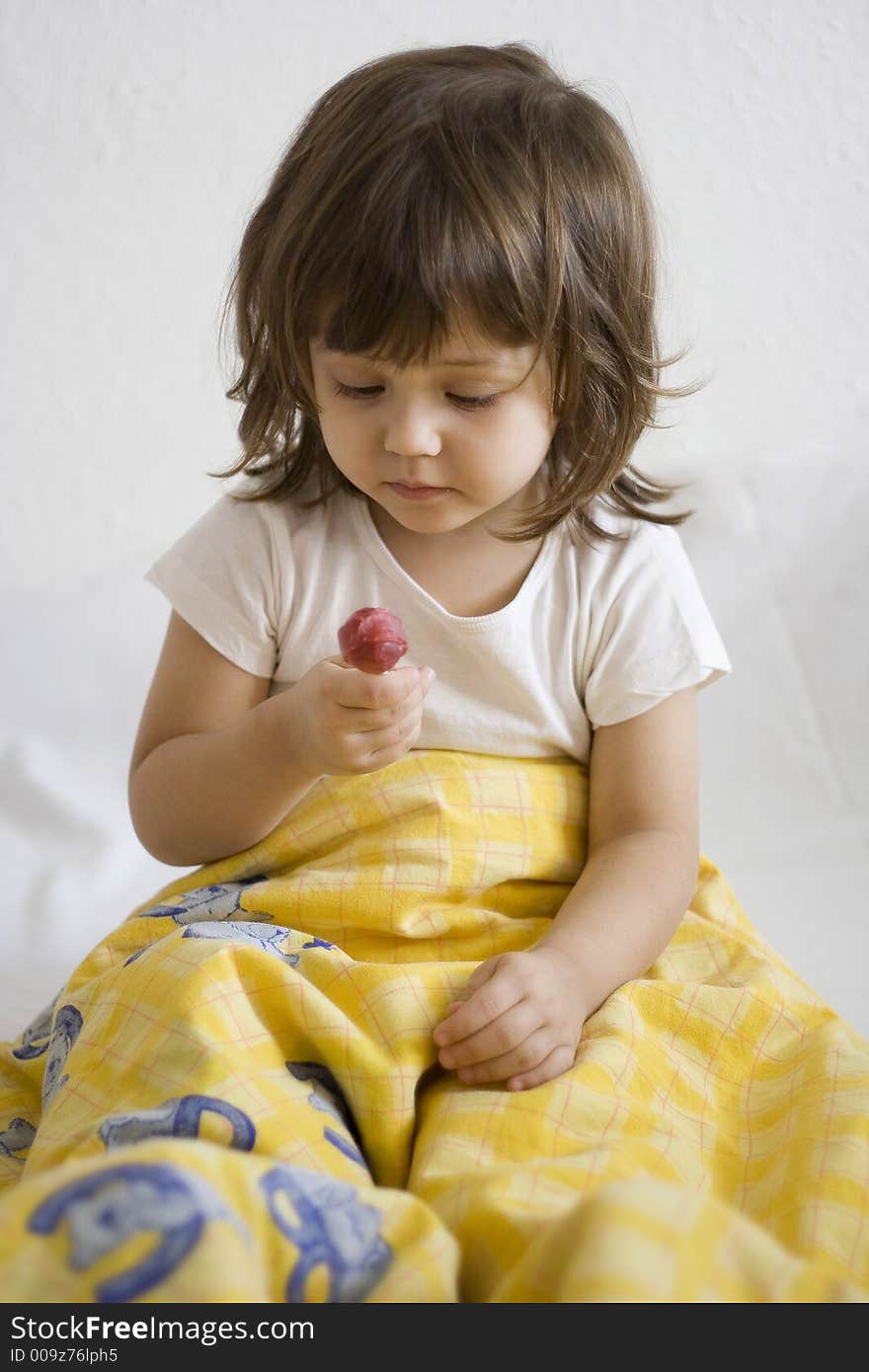 Little girl looking at her lollipop with love