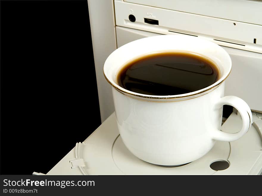 Cup of black coffee on CD-ROM, isolated on black