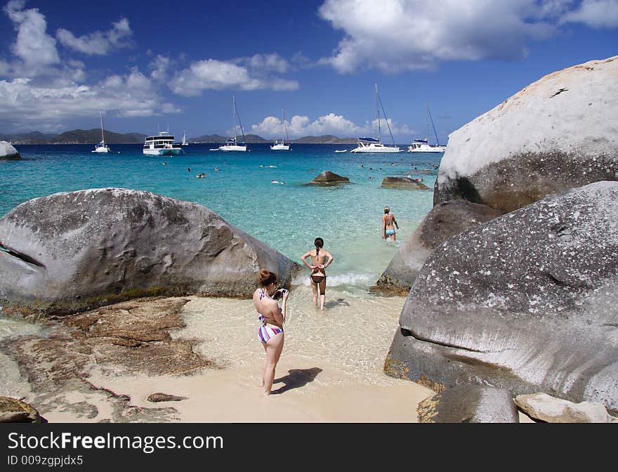 Young woman on a tropical beach with large granite rocks. Young woman on a tropical beach with large granite rocks