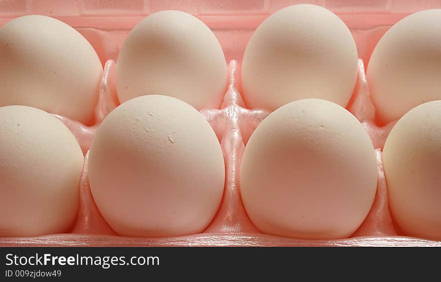 Closeup of White eggs in pink carton