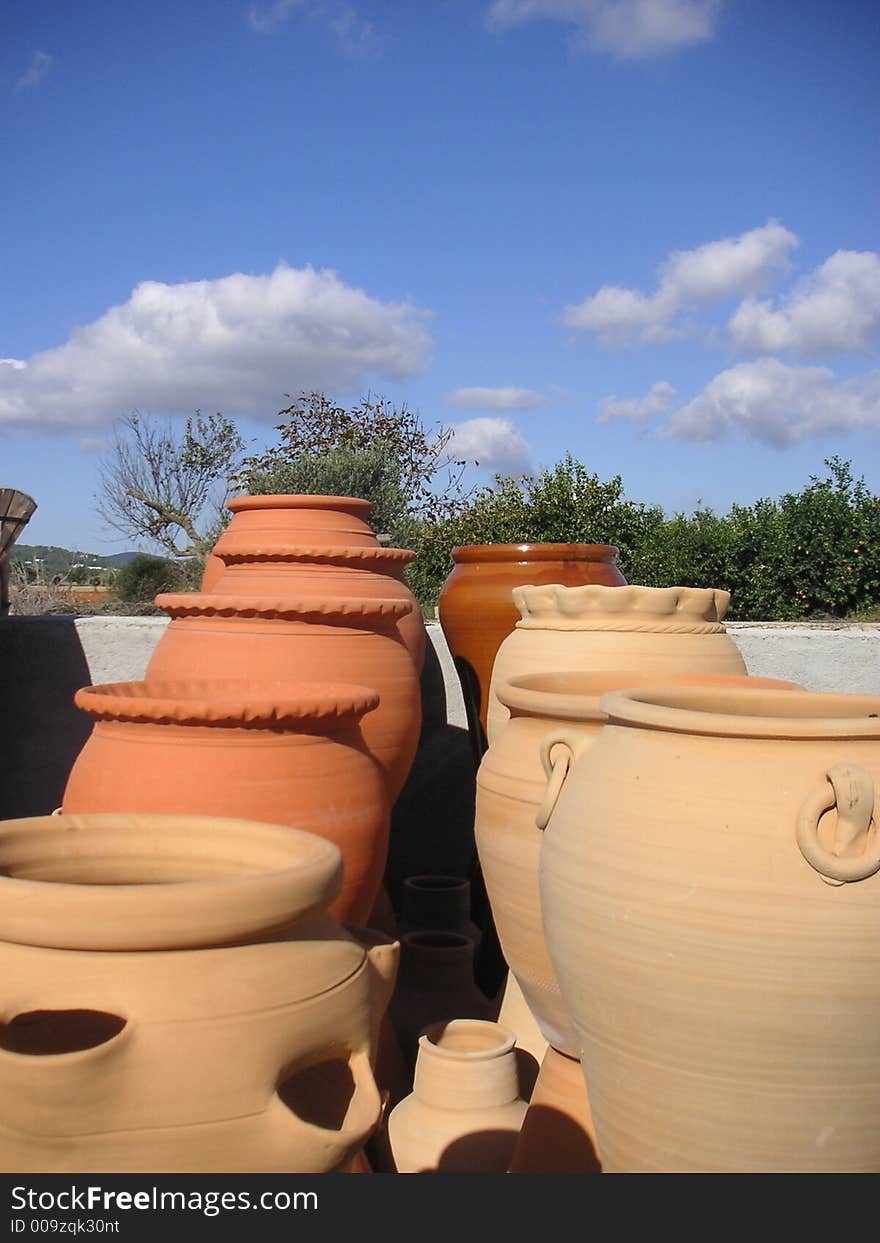 Spanish garden detail with terra-cotta pottery under a deep blue sky. Spanish garden detail with terra-cotta pottery under a deep blue sky