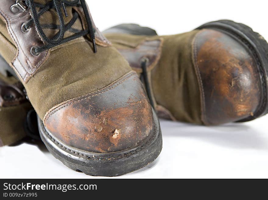 A pair of old boots that appear well worn and rugged.