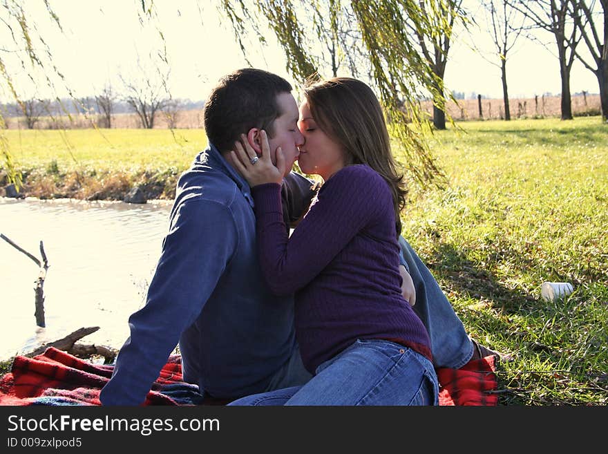 Young couple sitting under a tree. Young couple sitting under a tree