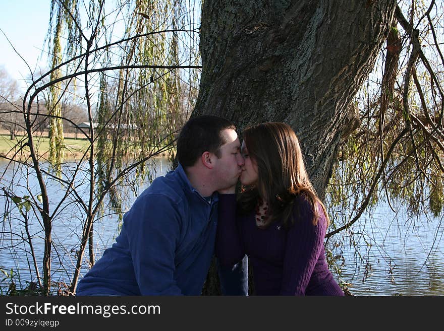 Young couple sitting under a tree. Young couple sitting under a tree