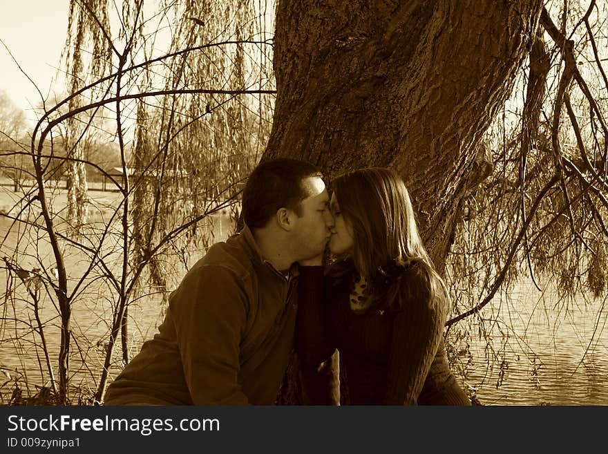 Young couple sitting under a tree. Young couple sitting under a tree