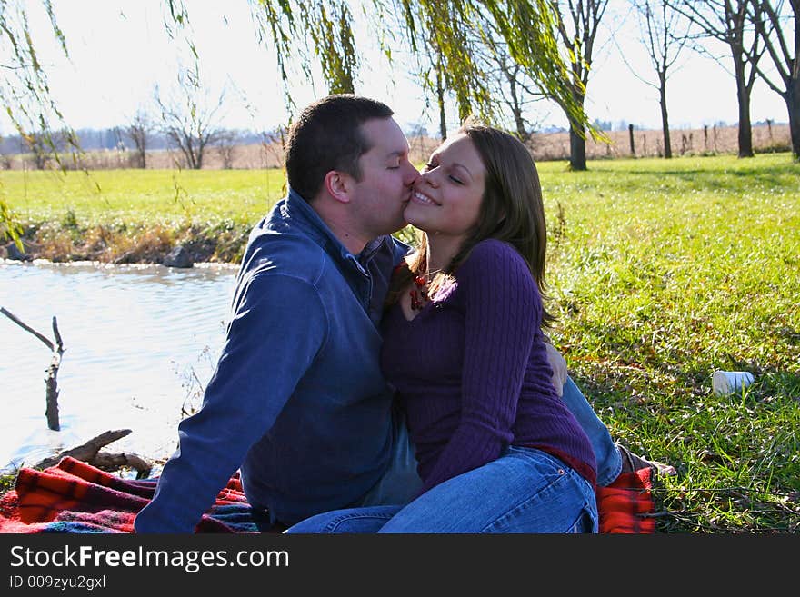 Young couple sitting under a tree. Young couple sitting under a tree