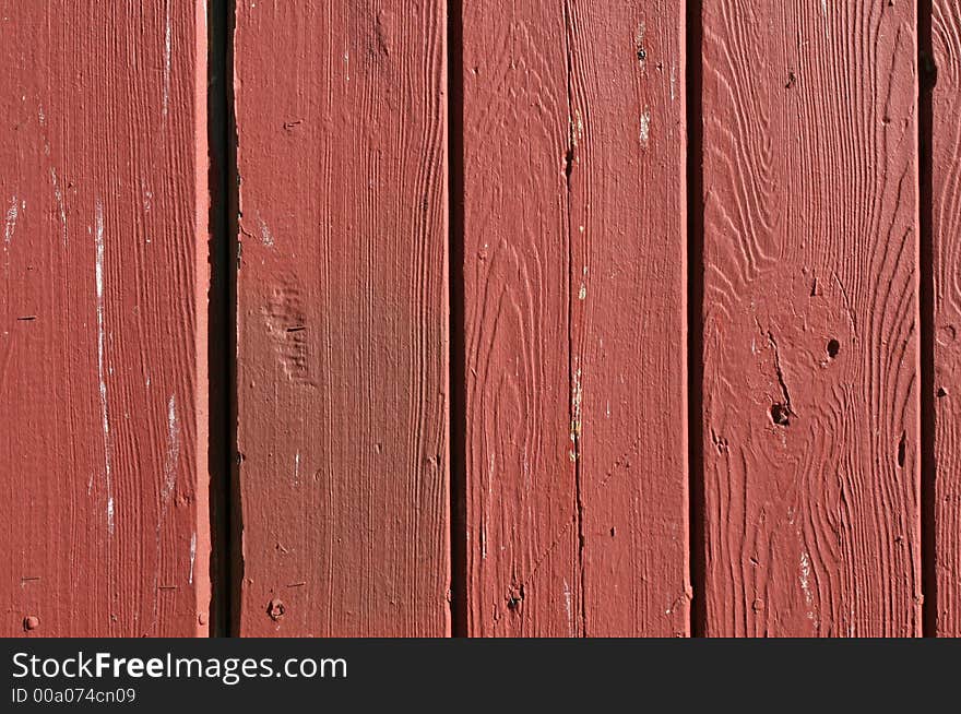 Detail on the boards and grain of a red fence. Detail on the boards and grain of a red fence