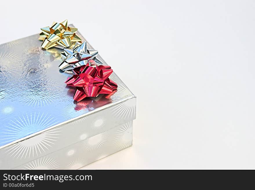 Gold, silver & red bows on top of a silver christmas present - against a white(ish) background. Gold, silver & red bows on top of a silver christmas present - against a white(ish) background