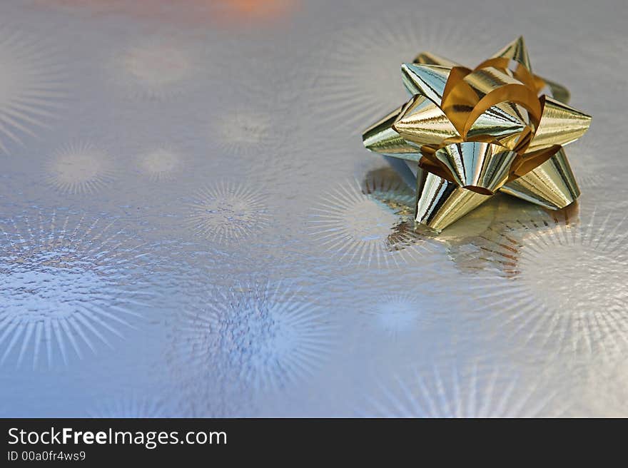 Gold bow detail on top of a sivler present. Gold bow detail on top of a sivler present