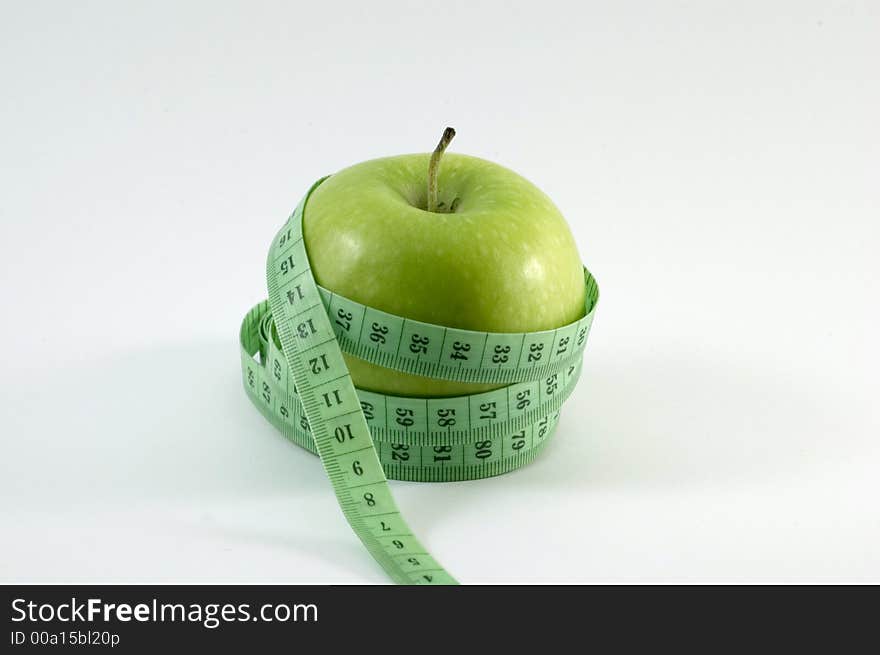 Apple surounded by a 	
metric ribbon in white background. Apple surounded by a 	
metric ribbon in white background