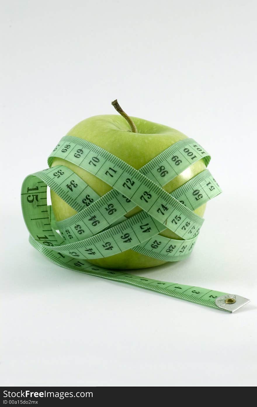 Apple surounded by a 	
metric ribbon in white background. Apple surounded by a 	
metric ribbon in white background