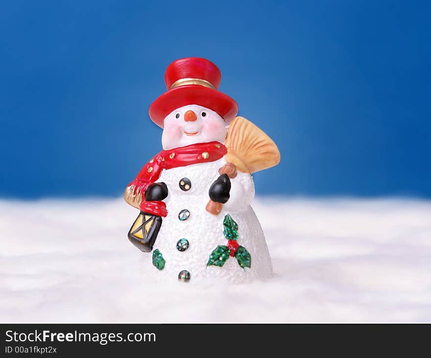 Snowman with red hat over deep blue sky. Snowman with red hat over deep blue sky