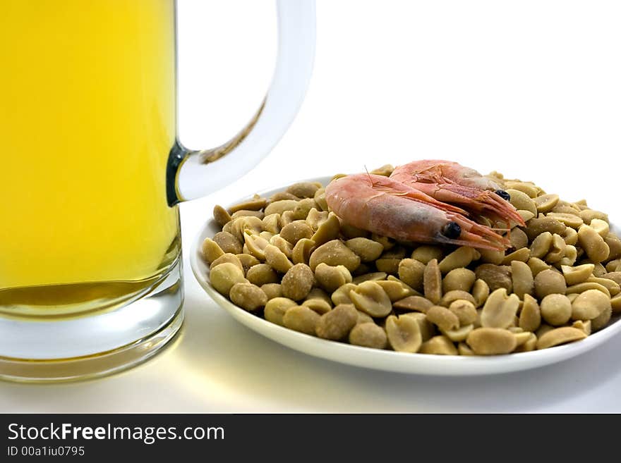 Two mugs of beer and plate with snacks.