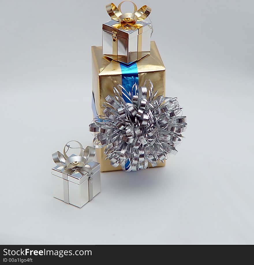 Vertical trio of gifts in gold silver and blue