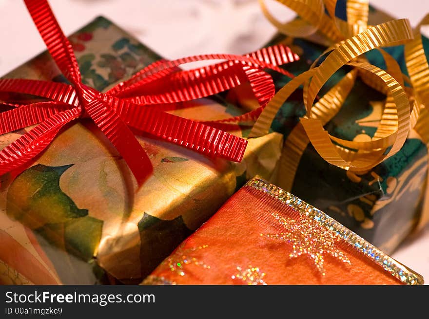 Christmas presents, gold, green and red, on white paper snowflakes. Christmas presents, gold, green and red, on white paper snowflakes.