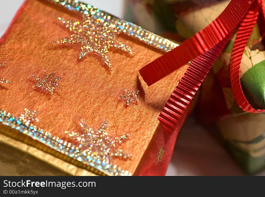 Christmas presents, gold, green and red, on white paper snowflakes. Christmas presents, gold, green and red, on white paper snowflakes.