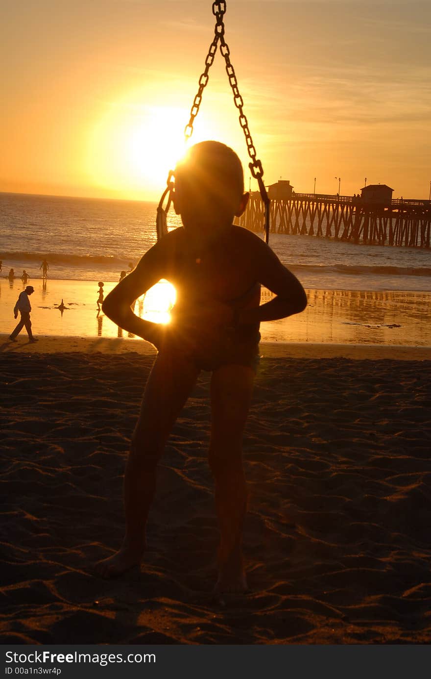 A boy on the swings on the beach