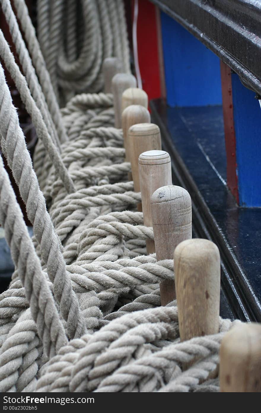 Coils of rope hung over a line of wooden pegs. Coils of rope hung over a line of wooden pegs