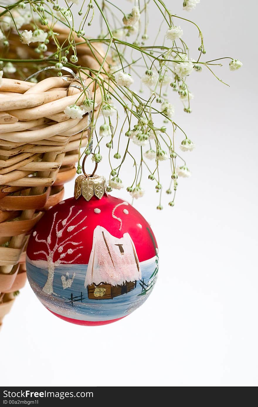 Red christmas ball, green branch and basket. With copy-space, white background. Red christmas ball, green branch and basket. With copy-space, white background