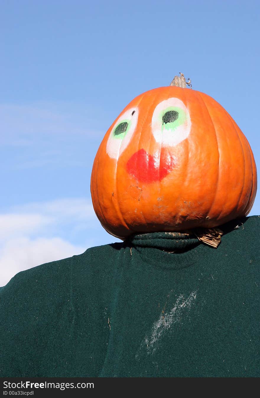 Pumpkin person against a blue sky. This is part of a display in Canada for Halloween.