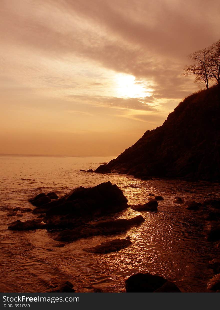 Sea shore, sunset, cliff, sea, rocks, sky, clouds, sun, red. Sea shore, sunset, cliff, sea, rocks, sky, clouds, sun, red