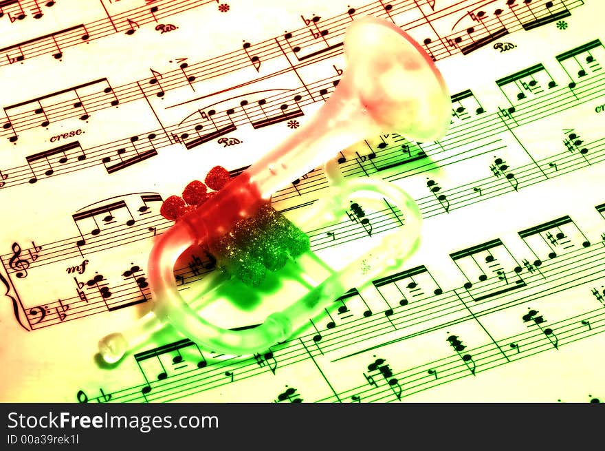 Photo of a Trumpet Ornament on SHeetmusic - Christmas Carol. Photo of a Trumpet Ornament on SHeetmusic - Christmas Carol