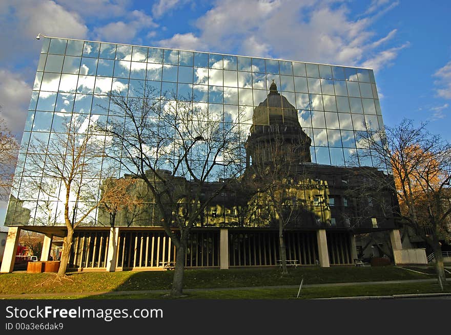 Office building details reflecting, blue sky and clouds in windows