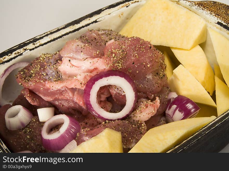 Meat, potatoes, and onion ready to cook