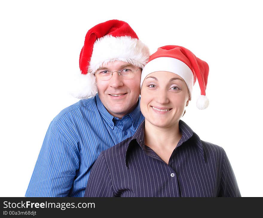 Portrait of young happy couple wearing red santa hats over white background. Portrait of young happy couple wearing red santa hats over white background