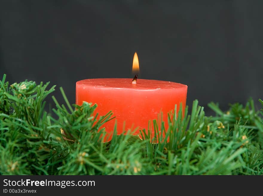 Red candle burning on black background