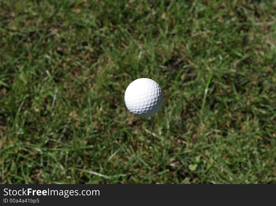 Golf ball mid flight suspended in mid air