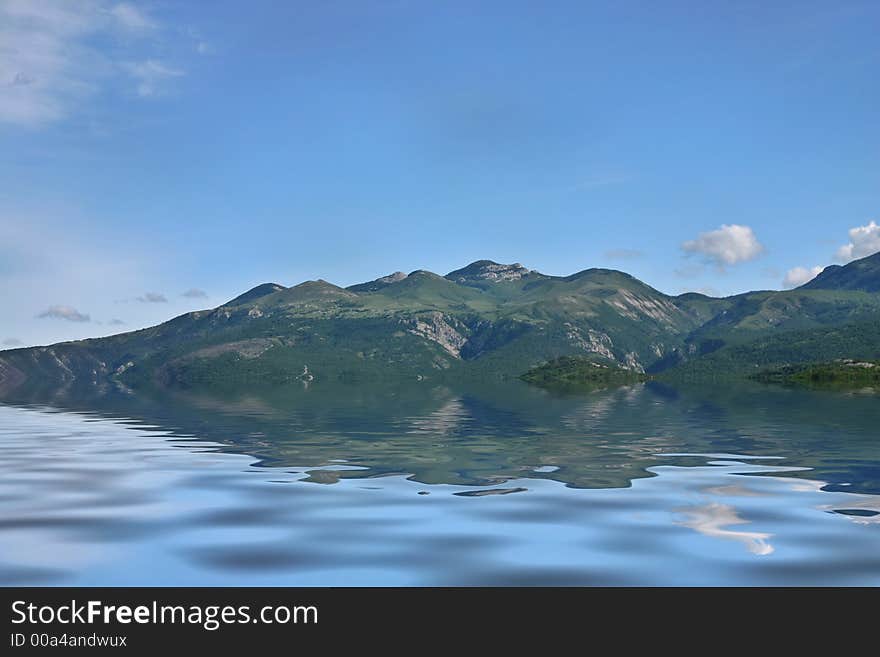 Green mountain slopes with reflection