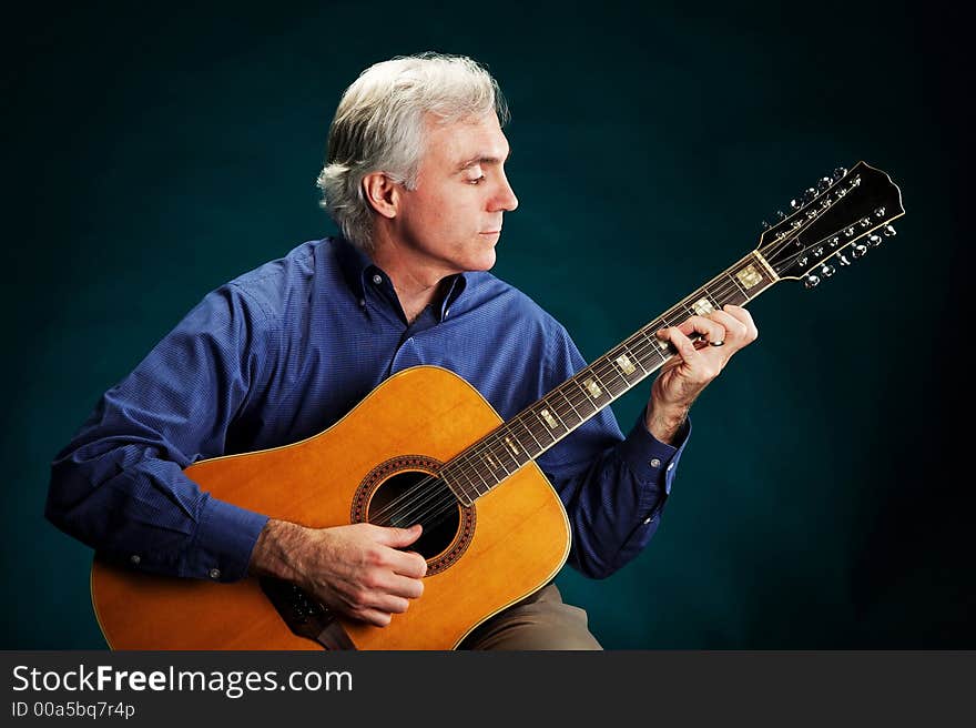 Portrait of a guitarist playing a 12-string guitar. Portrait of a guitarist playing a 12-string guitar.
