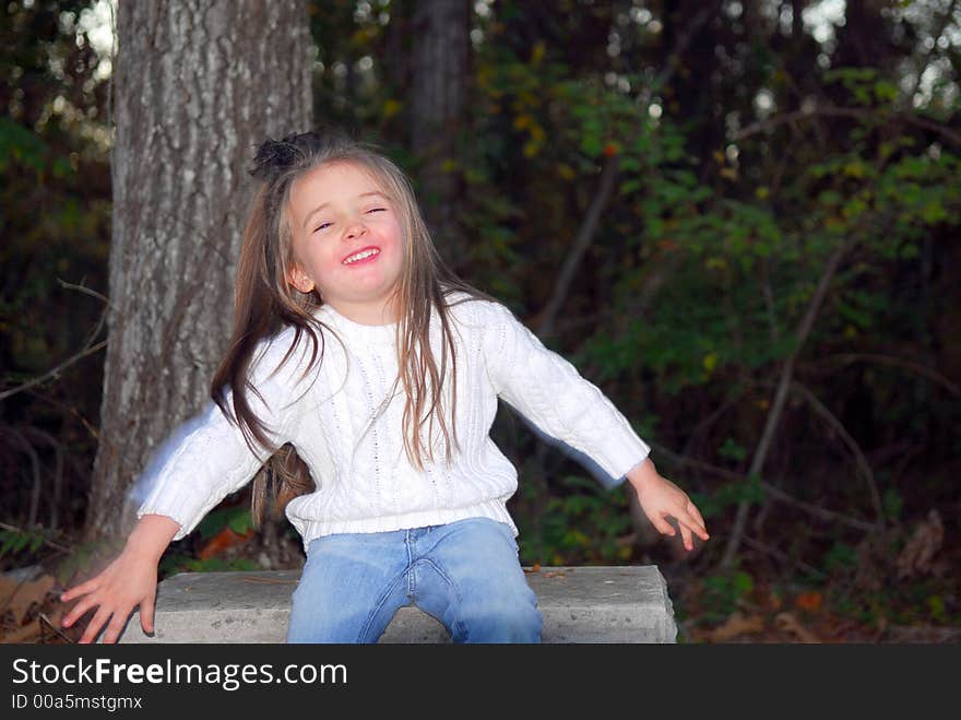 A beautiful little girl acting very silly during a photo shoot.  She has a funny face.