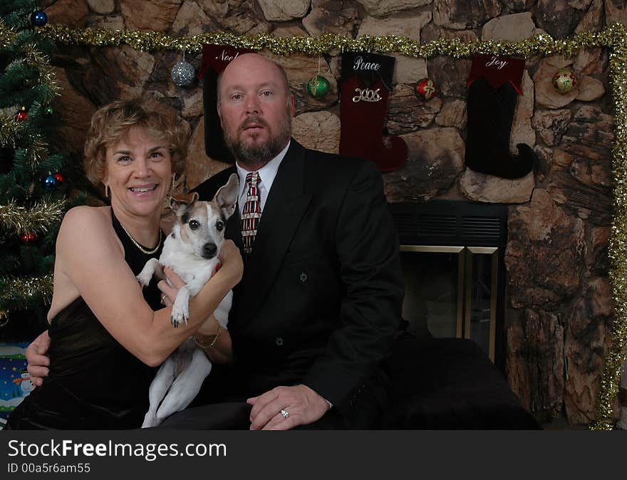 Couple with their dog in front of the Christmas tree. Couple with their dog in front of the Christmas tree