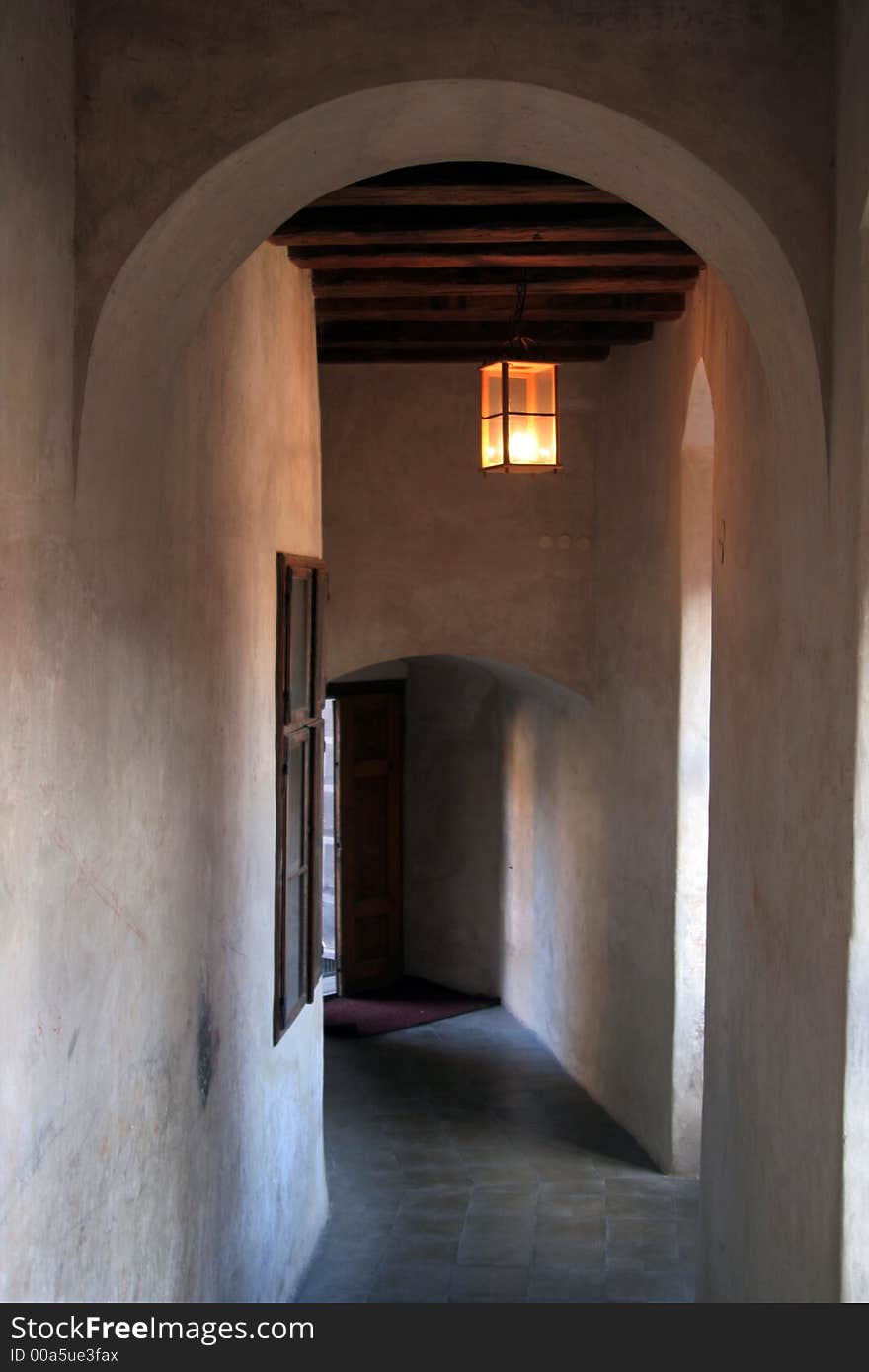 Long and old castle hallway with lantern