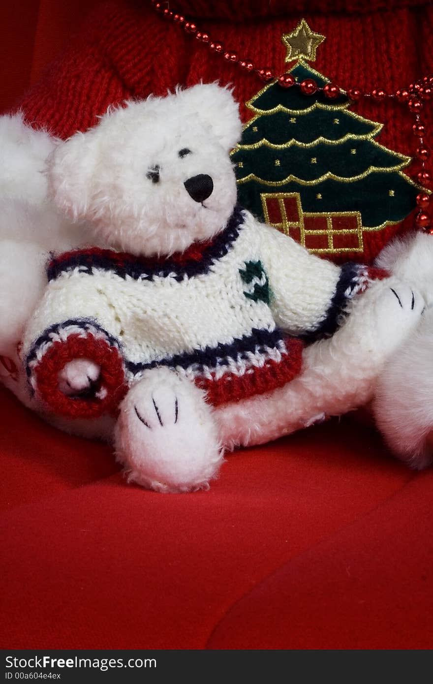 White Christmas teddy bear sitting on a red chair