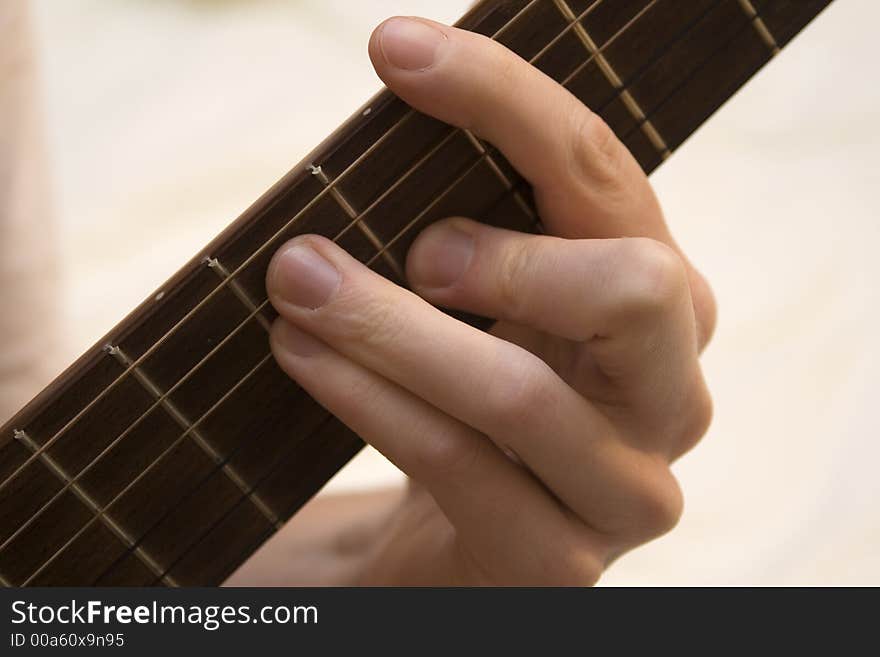 A hand playing a guitar Chord